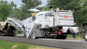 Cold-in-place recycling additive system allows milling and paving a roadway in a single process