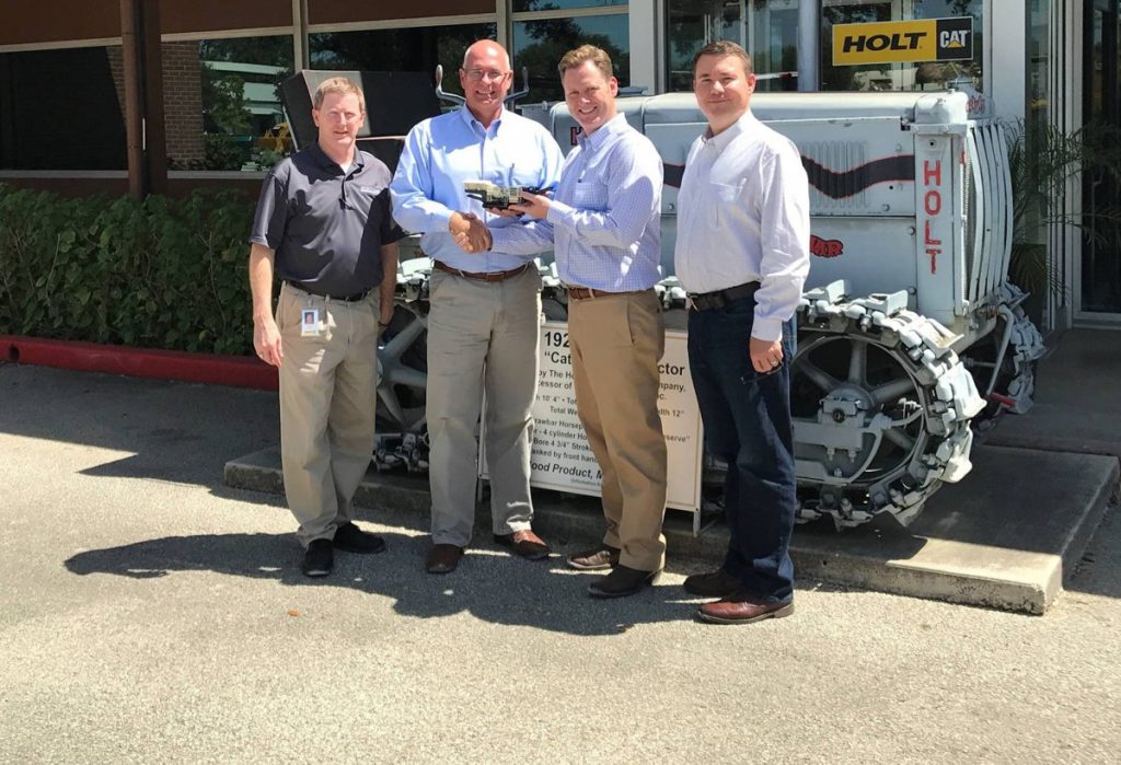 Distribution manager Nayles Bakke from Metso presents the new distribution partner HOLT with a model of a Lokotrack mini crusher. From left: Buck Pate, technical services manager at HOLT; Nayles Bakke, Metso; Evan Creson, VP, Machine Sales South at HOLT; J.K. Baxter Senior, VP, Machine Sales at HOLT.