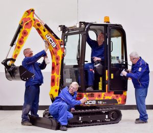 Pictured left to right are JCB employees John Watson, Andy Minor, Sean Bowers and Mick Capper putting finishing touches to the machines decoration