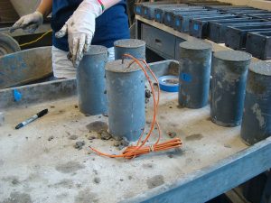 Concrete test cylinders being made with embedded sensors