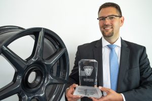 CEO Dr. Jens Werner with the SPE award and the braided carbon wheel.