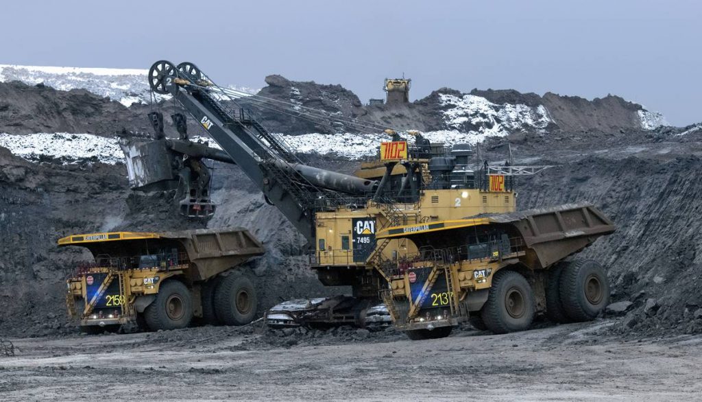 Two Cat 797F autonomous trucks being loaded in pit