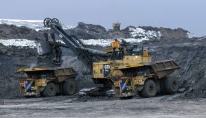 Two Cat 797F autonomous trucks being loaded in pit