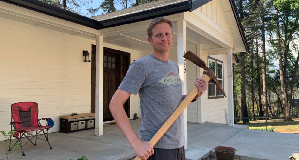 Charles Brooks and his pick-ax, with replacement handle, recovered from the ashes. Photo by Tyler Brooks