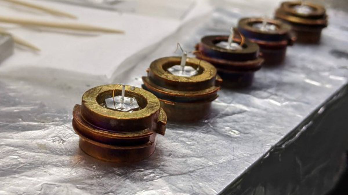 Image courtesy of former Berkeley Lab researcher Daniel Eilbott Image of doped CeCoIn5 samples resting on copper “puck” sample holders. (Each puck is approximately the size of a silver dollar.) The Berkeley Lab-led team used spectroscopic techniques at the Advanced Light Source to image the CeCoIn5 crystals’ electronic energy structure as a function of chemical composition.