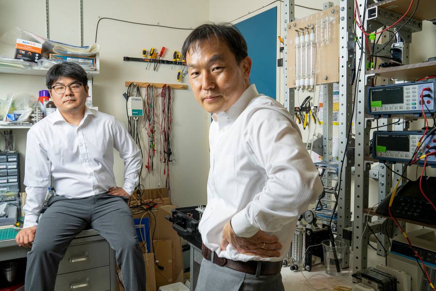 MIT researchers have created a portable desalination unit that can automatically remove particles and salts simultaneously to generate drinking water. “This is really the culmination of a 10-year journey that I and my group have been on,” says senior author Jongyoon Han, right, pictured with Junghyo Yoon, seated. Image credit M. Scott Brauer.
