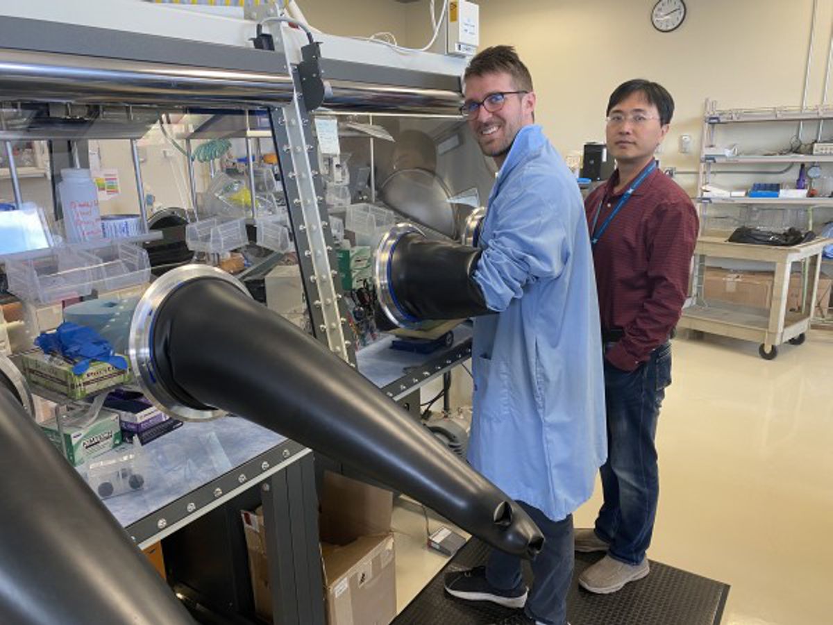 Credit: Idaho National Laboratory Corey Efaw (left) sets up Lithium-Sulfur coin cells in the glove boxes as Dr. Bin Li (right) observes. INL partnered with Cogent through the Technical Assistance Program (TAP) to test new battery capabilities.