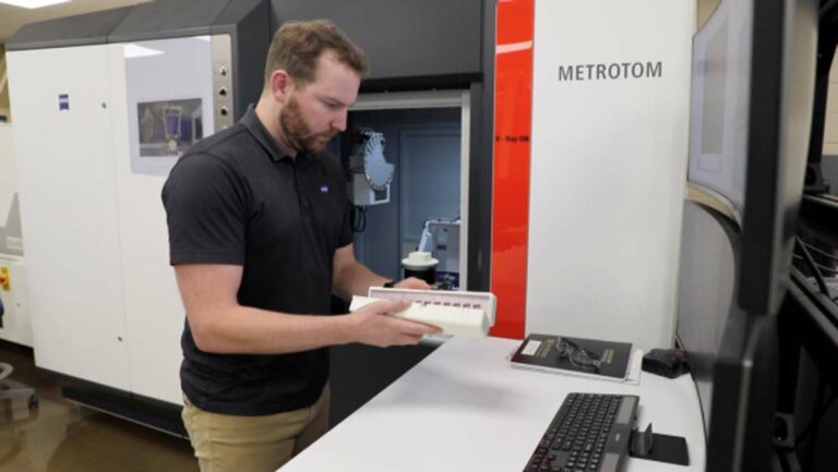Credit: Brittany Cramer/ORNL, U.S. Dept. of Energy Paul Brackman loads 3-D printed metal samples into a tower for examination using an X-ray CT scan in DOE's Manufacturing Demonstration Facility at ORNL.