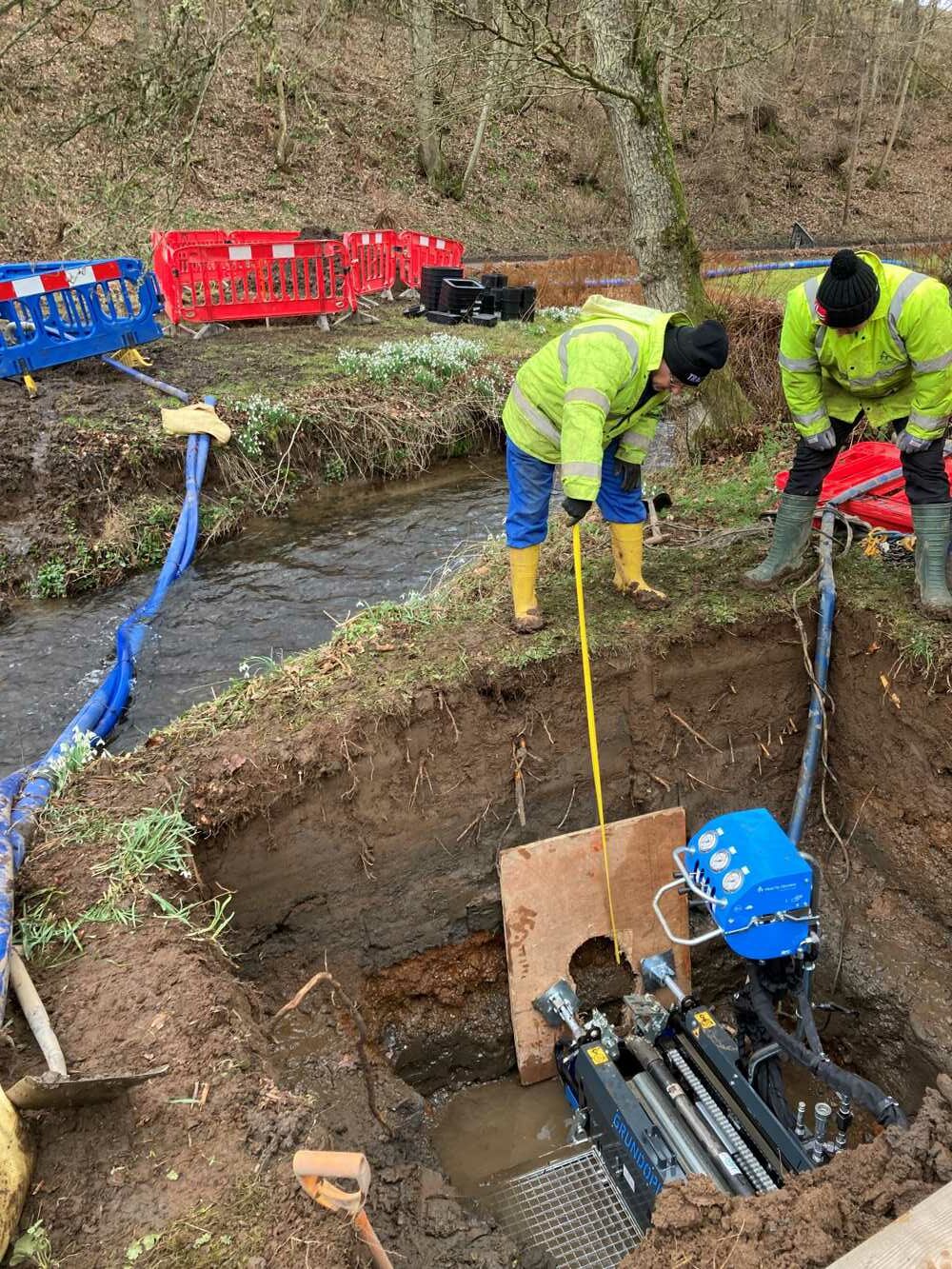 Running a water pipe under a stream with a TRACTO PS60 GRUNDOPIT