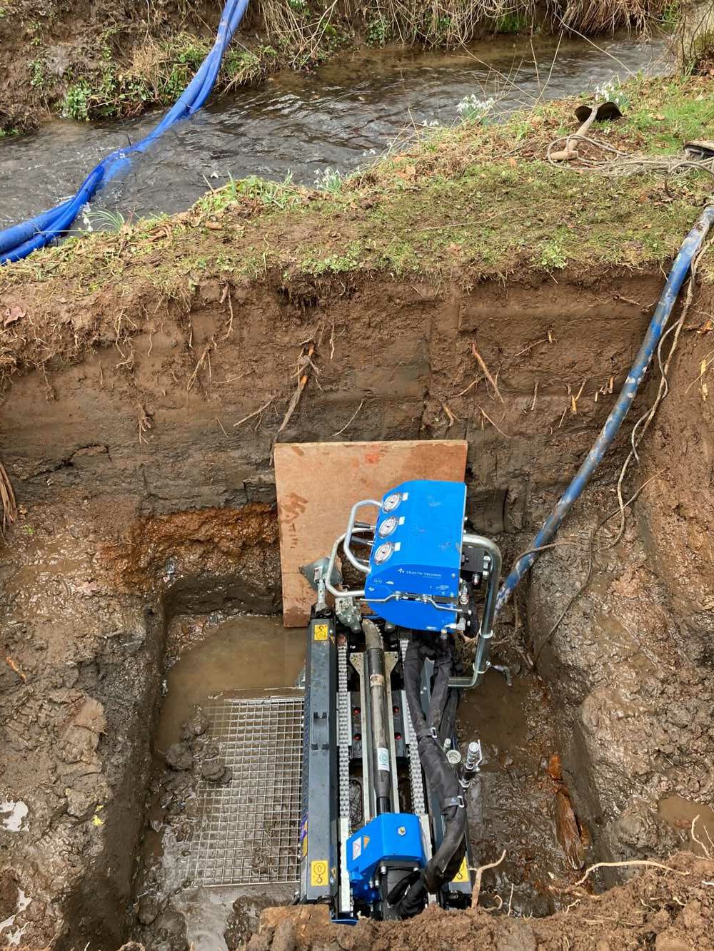 Running a water pipe under a stream with a TRACTO PS60 GRUNDOPIT