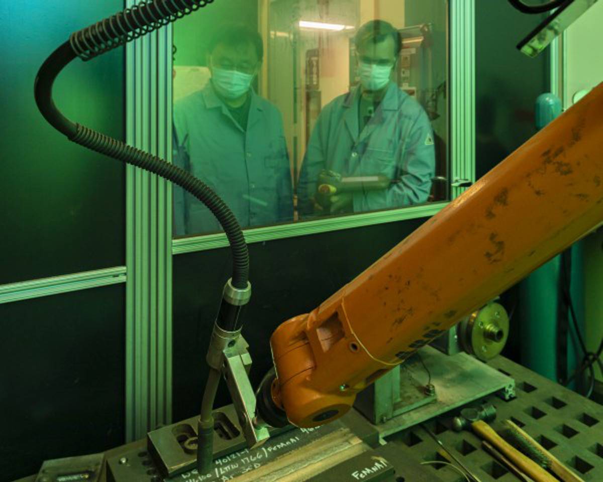 Credit: Carlos Jones/ORNL, U.S. Dept. of Energy Oak Ridge National Laboratory materials scientist Zhili Feng, left, looks on as senior technician Doug Kyle operates a welding robot inside a robotic welding cell.