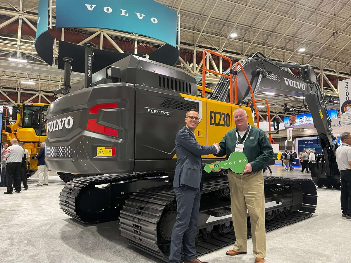 Martin Mattsson, Key Accounts Director — Waste and Recycling at Volvo CE (left), hands over the EC230 Electric keys to Harold Romberg, Director of Heavy Equipment for WM, at Waste Expo.