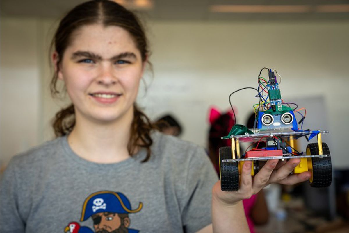 Credit: (Image by Argonne Institutional Partnerships.) Camper Emily Boyd displays the vehicle that she and her team built for the camp.