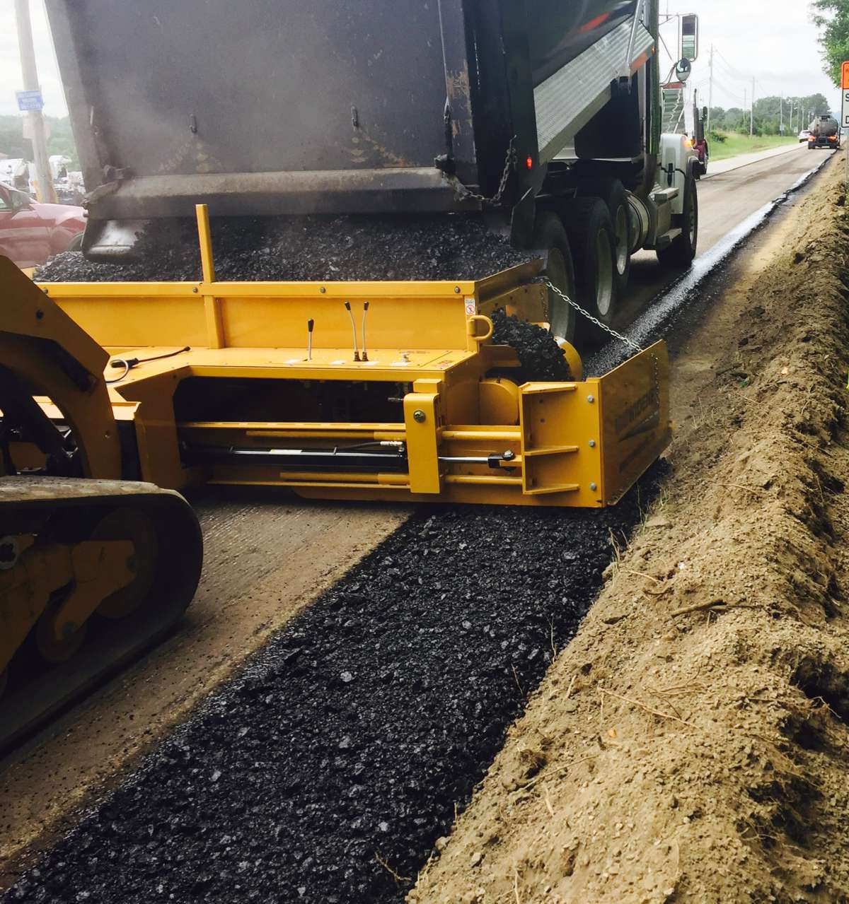 ODOT used the Road Widener FH-R skid steer attachment to efficiently disperse material from a dump truck to the material box, and then carefully onto the roadway. Using it resulted in increased efficiency, reduced labor and decreased costs.
