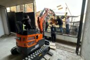 Using a Develon Mini-Excavator to install Large Glass Panels