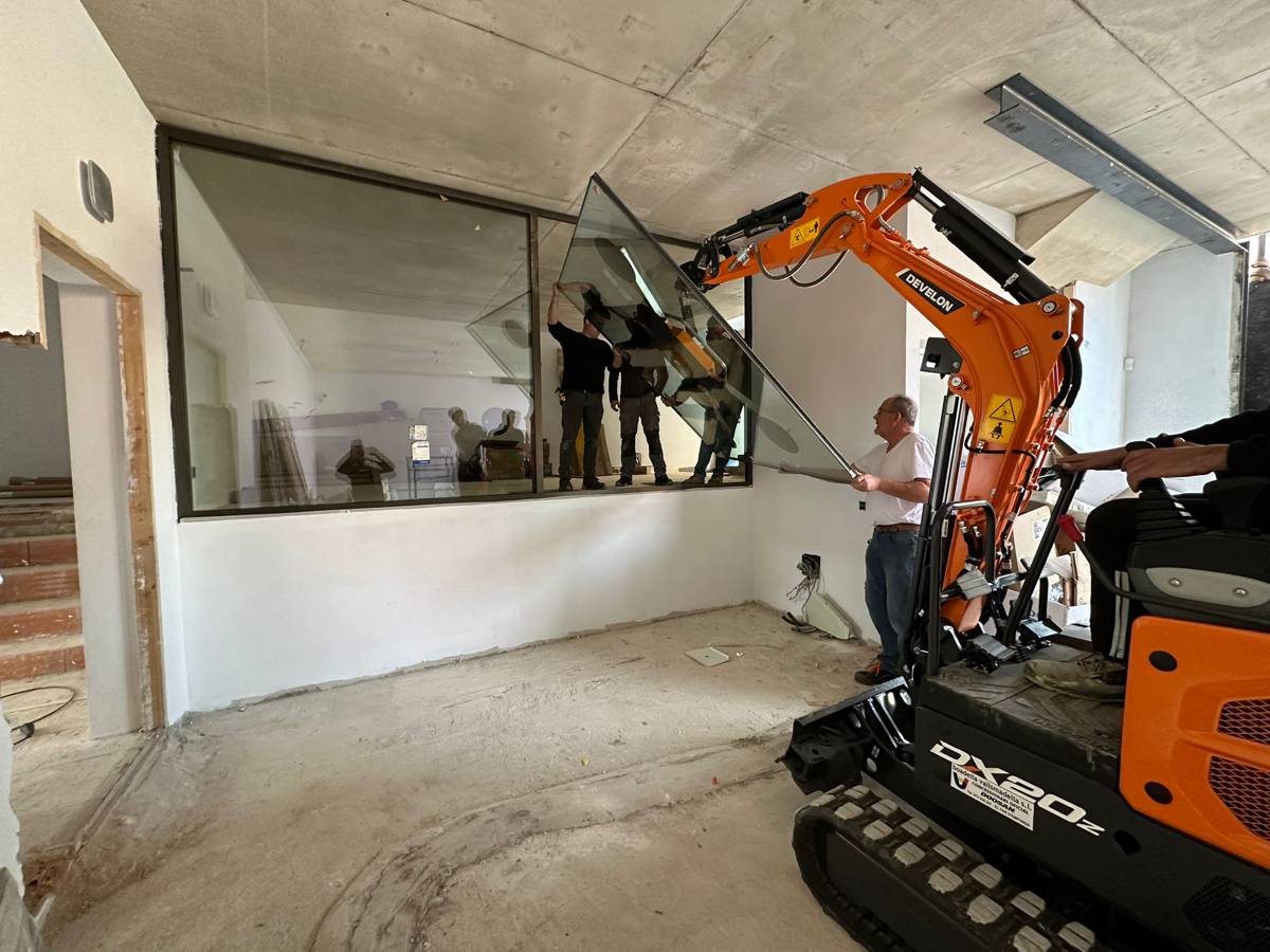 Using a Develon Mini-Excavator to install Large Glass Panels